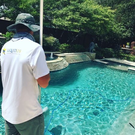During Pool Cleaning, a Tech gets the last bits of debris out of the pool