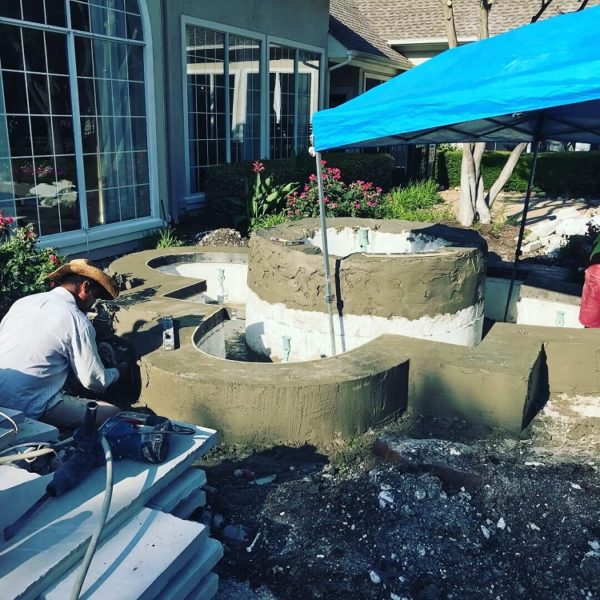 A Liquidus Pro works on remodeling a water feature