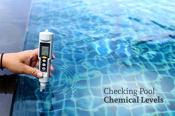 A person using an electric pool test kit with the words checking pool chemical levels