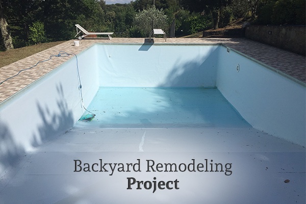 A look into a pool remodel, the pool is currently empty, with the words, backyard remodeling project.