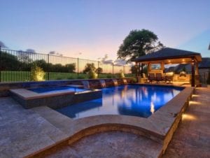 Beautiful well-lit custom backyard pool at sunset