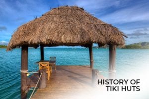A Tiki Hut surrounded by beautiful crystal clear water, with the words, history of tiki huts.