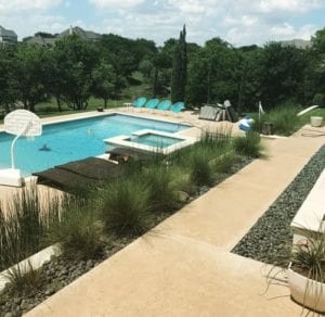 a backyard with a pool and landscaping