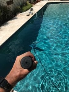 a mans hand cleaning a pool