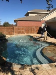 a man cleaning out a pool with a net