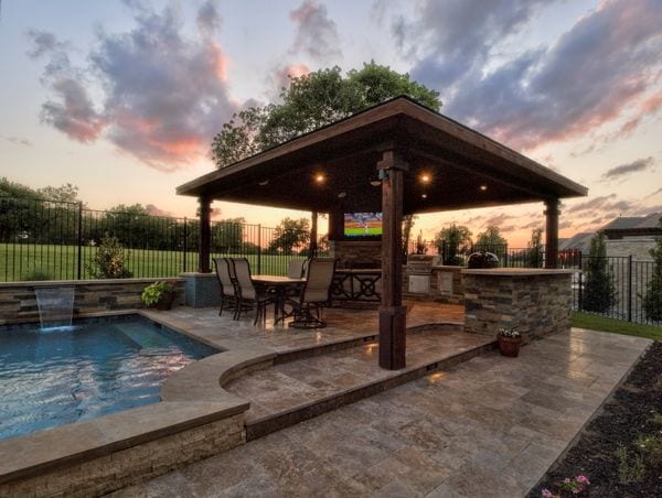 A gorgeous outdoor pool and kitchen area in sunset.