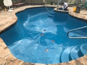 a drained pool getting a cleaning