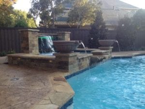 A gorgeous fountain next to an outdoor pool.