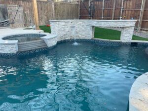 a newly built pool with spa and water fountain