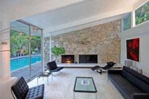 A gorgeous stone fireplace near an outdoor pool. 